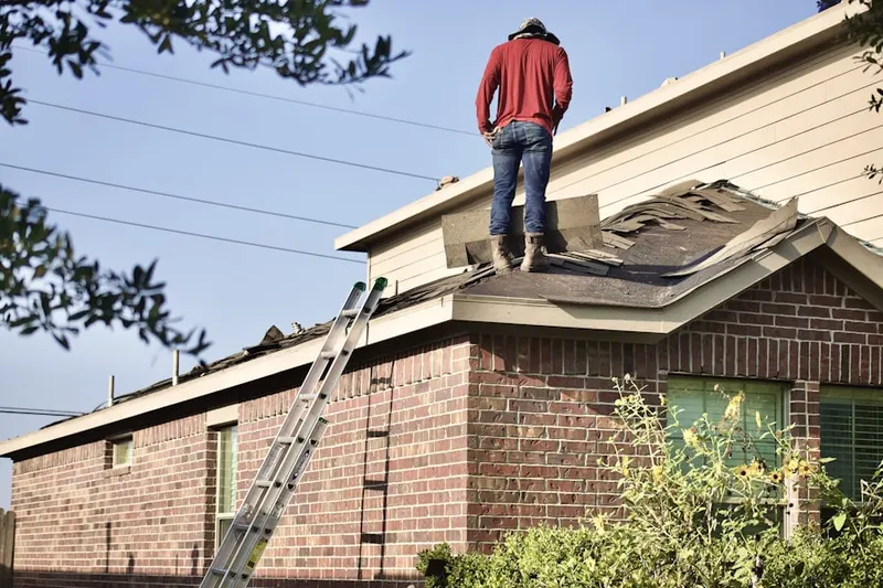 Professional roofer working on a residential roof in Willow Bend